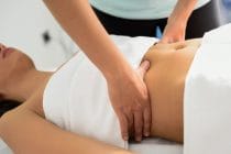 massagetherapeut voert buikmassage uit