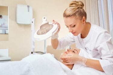 Schoonheidsspecialiste voert een huidanalyse uit in een beauty salon