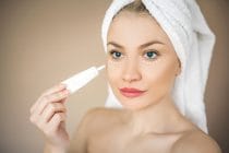 vrouw brengt een serum aan onder haar ogen