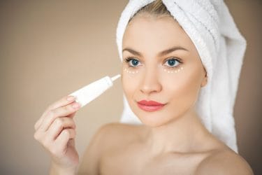 vrouw brengt een serum aan onder haar ogen