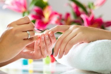 Nagelstyliste verzorgt nagels van klant .