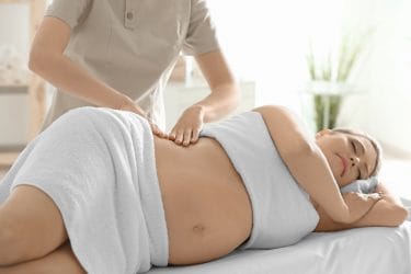zwangere vrouw ontvangt een professionele zwangerschapsmassage