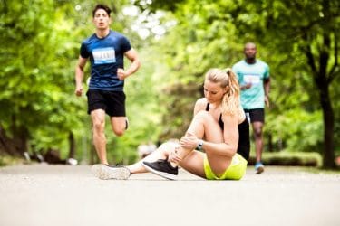 Jonge vrouw valt tijdens het rennen en heeft een verstuikte enkel.