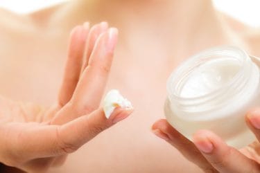 Vrouw toont een van haar gezichtsproducten voor haar dagelijkse beauty routine