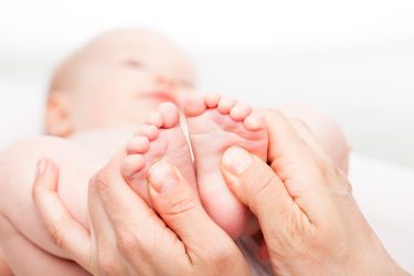 Baby ontvangt reflexologie behandeling
